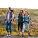 Three young people are hiking outdoors on a sunny day.